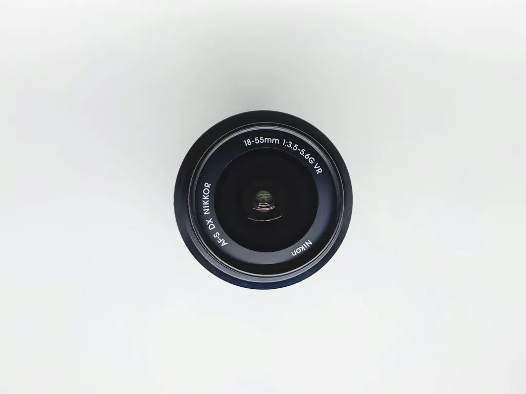 A black camera lens on a white surface