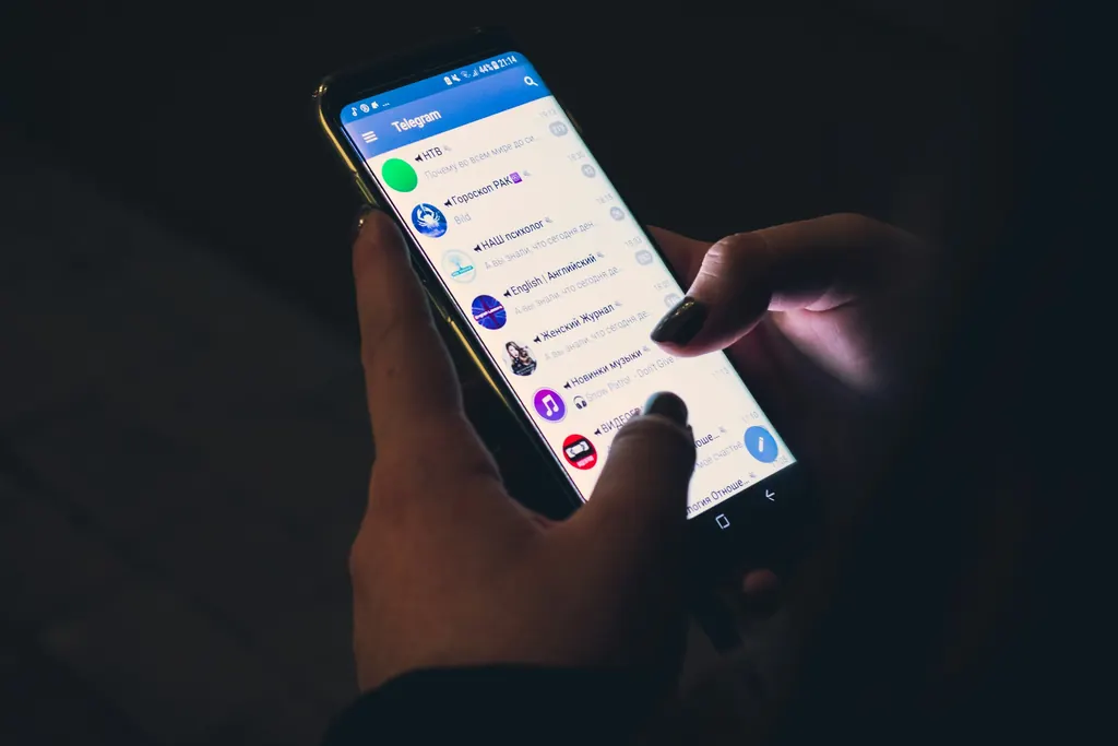 A hand holding a smartphone in the dark